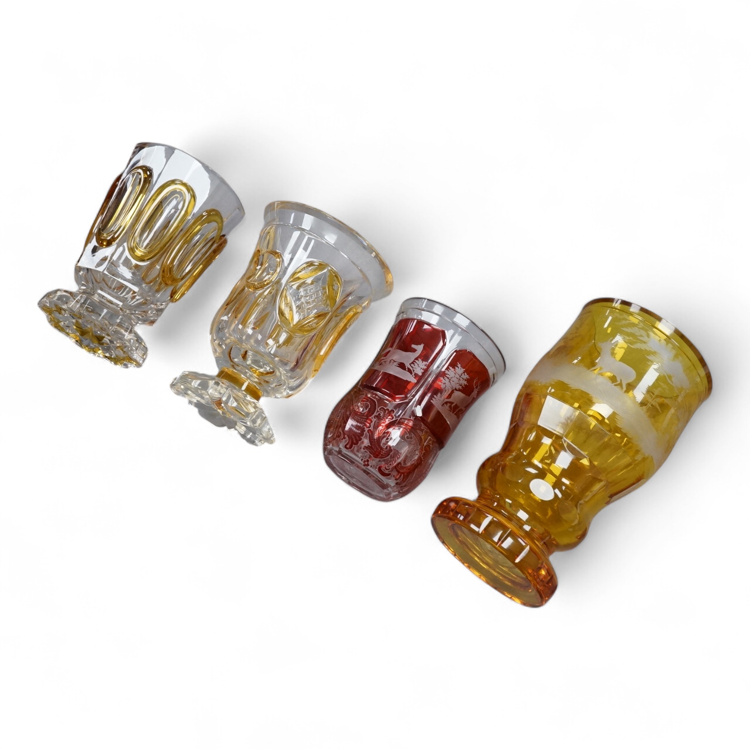 Four Bohemian engraved amber or ruby flashed ‘hunting’ goblets or beakers, late 19th century, tallest 15cm high